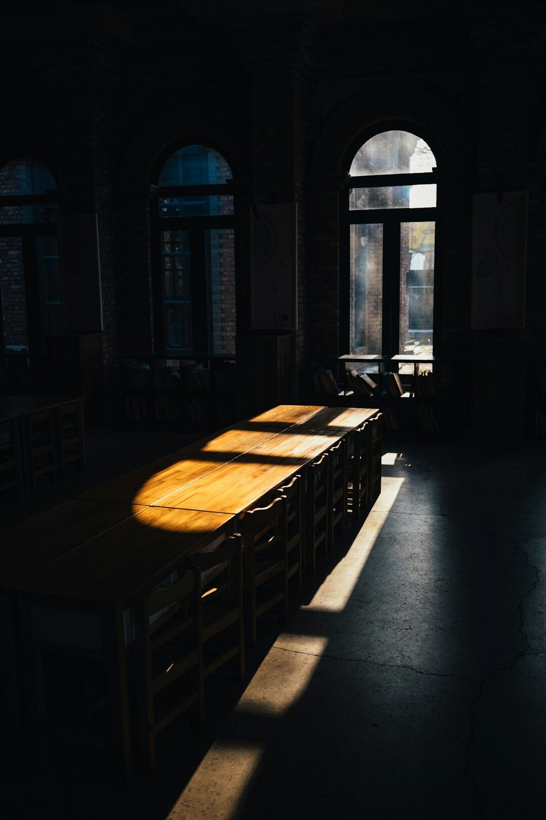 Empty museum reading room with wooden desks and soft light